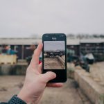 a person holding up a cell phone to take a picture